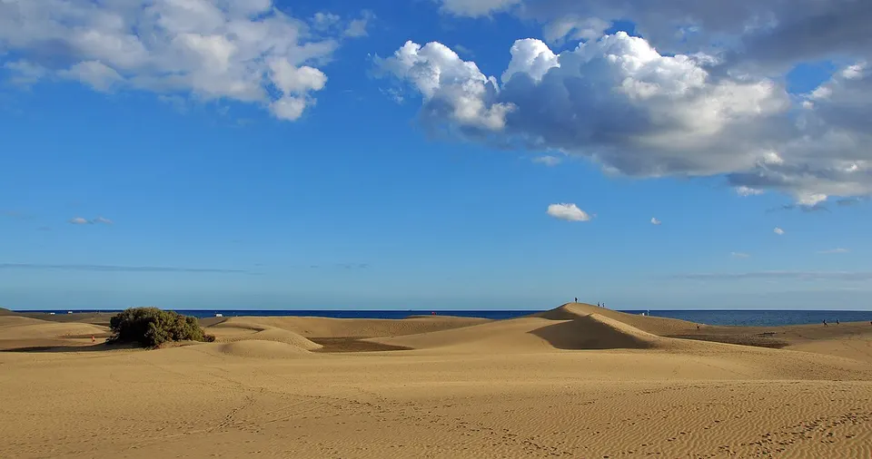 Die goldenen Sanddünen von Maspalomas auf Gran Canaria unter blauem Himmel