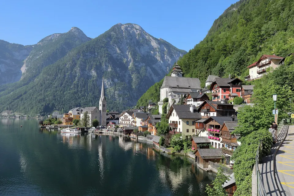 Das Dorf Hallstatt am Ufer des Hallstätter Sees mit Kirchturm und bewaldeten Bergen