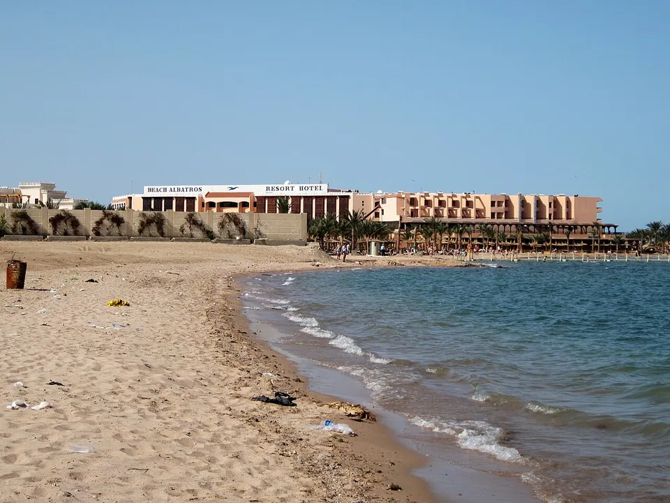 Hotelstrand in Hurghada mit Sonnenschirmen, Palmen und türkisfarbenem Roten Meer
