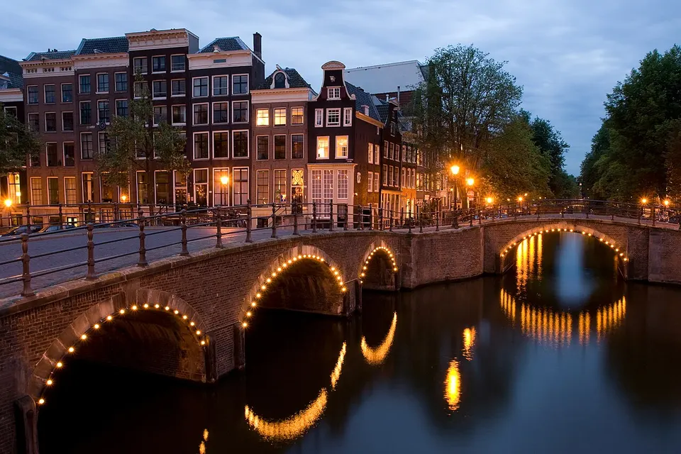 Amsterdam: A view of the Reguliersgracht on the corner with the Keizersgracht, in Amsterdam, the Netherlands at dusk.