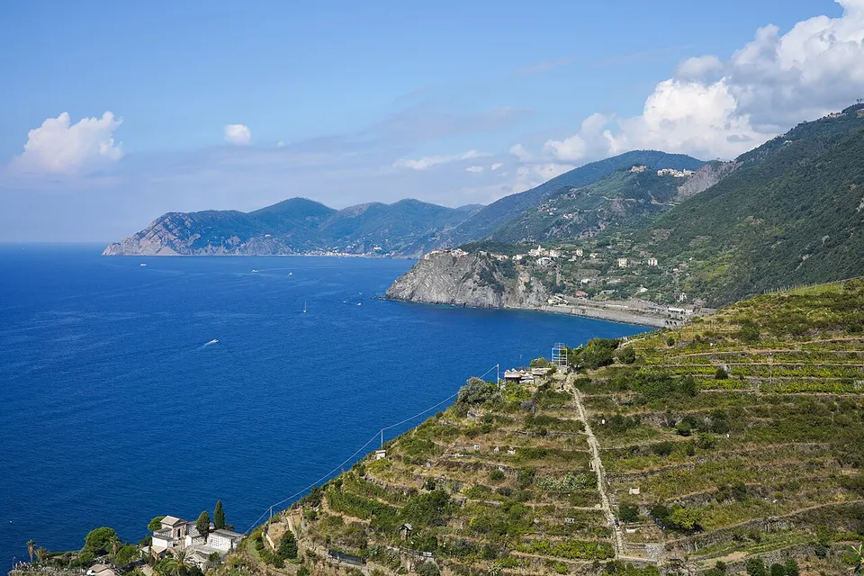Cinque Terre: View of coastline NW from above Manarola: Manarola cemetery and fields and steep trail to Volastra in foreground, Corniglia Station and town