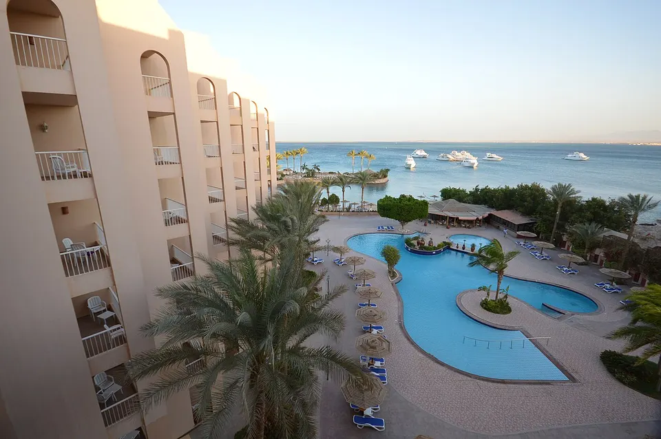 Großer Pool einer Hotelanlage in Hurghada mit Palmen und Sonnenliegen