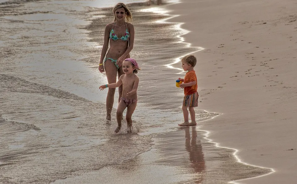 Mutter mit zwei Kindern am Sandstrand von Punta Cana in der Dominikanischen Republik