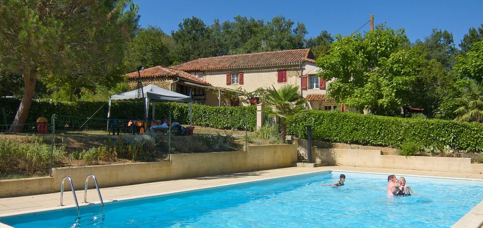 Pool eines Campingplatzes in Pouylebon im Südwesten Frankreichs mit einem Gebäude im Hintergrund