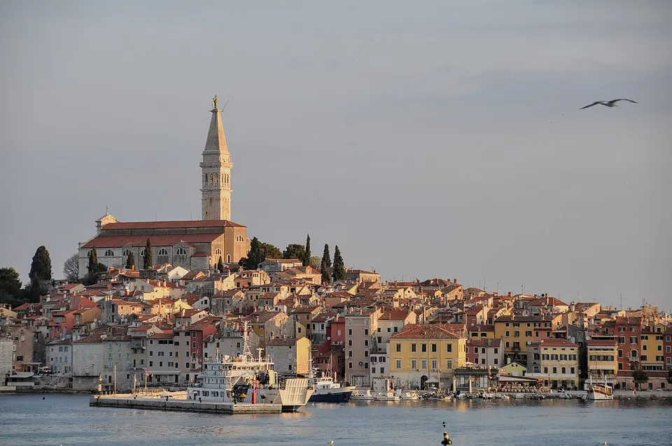 Die Altstadt von Rovinj in Istrien mit Kirchturm am Meer im Licht des Sonnenaufgangs