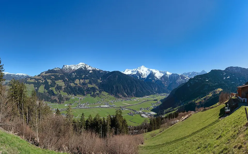 Panorama des Zillertals in Tirol mit grünen Hängen, Dörfern im Tal und hohen Bergen